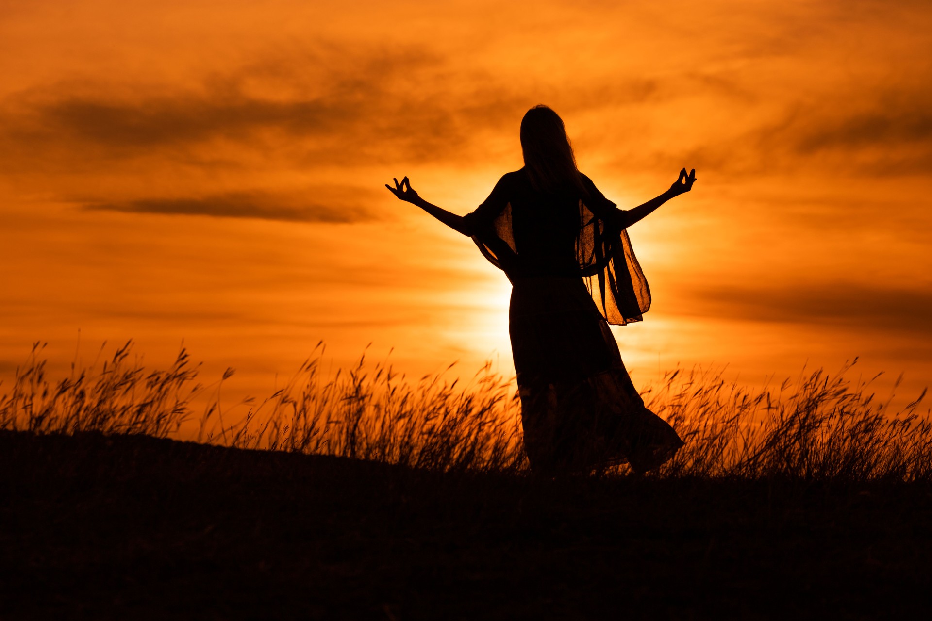 Silhouette of a woman meditate  at sunset